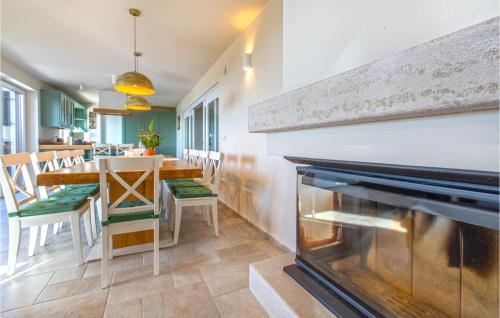 a dining room with a fireplace and a table and chairs at Amazing Home In Gracisce With Sauna in Gračišče