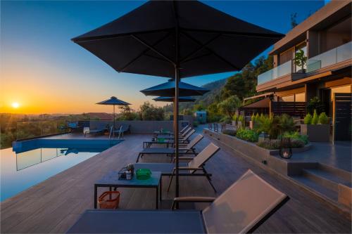 an outdoor patio with tables and umbrellas on a building at Anmian Suites in Vourvourou