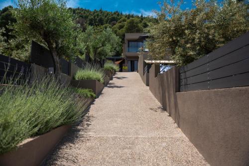 a sidewalk in front of a house with a fence at Anmian Suites in Vourvourou