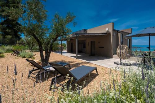 a house with a table and chairs in the desert at Anmian Suites in Vourvourou