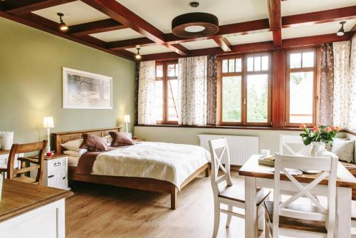 a bedroom with a bed and a table and chairs at Villa Filmowiec in Polanica-Zdrój