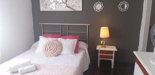 a bedroom with a bed and a table with a lamp at Casa Mary in Valles de Ortega