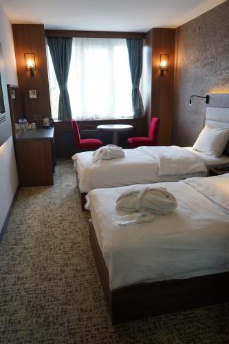a hotel room with three beds and a table and chairs at Hotel Kırcı Termal & Spa in Bursa