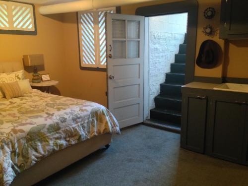 a bedroom with a bed and a staircase with a door at Stone Soup Inn in Indianapolis