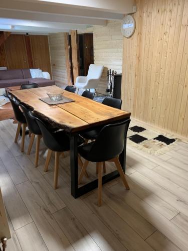 uma sala de jantar com uma mesa de madeira e cadeiras em Lucomi Chalet - For groups - 5 bedrooms em Poiana Ţapului