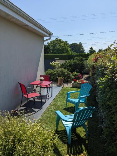 eine Terrasse mit 3 Stühlen und einem Tisch mit einem roten Tisch in der Unterkunft Au Beau Bouquet in Avremesnil