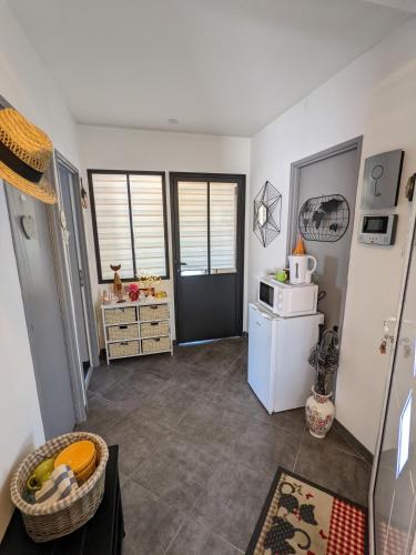 eine kleine Küche mit einem Kühlschrank und einer Mikrowelle in der Unterkunft Au Beau Bouquet in Avremesnil