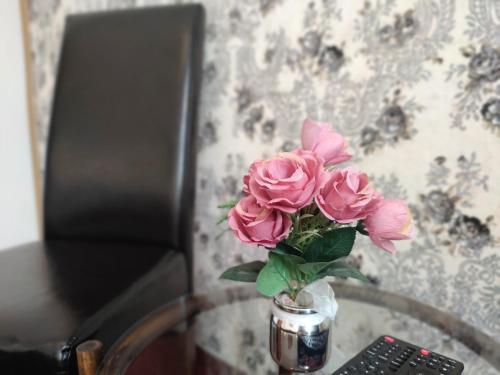 a vase filled with pink roses sitting on a table at Hotel Dejmalik in Litoměřice