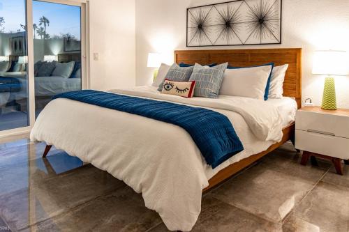 1 dormitorio con 1 cama grande con manta azul en Shaken not Stirred, en Palm Springs