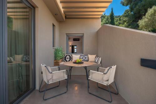 a patio with a table and chairs on a balcony at Anmian Suites in Vourvourou