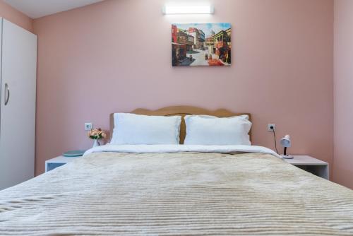 a bedroom with a large bed with two pillows at HB apartments Laghidze in Tbilisi City