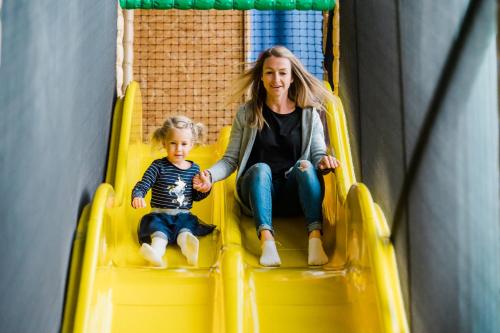a woman and a child riding on a slide at Momentum Hotel in Anif