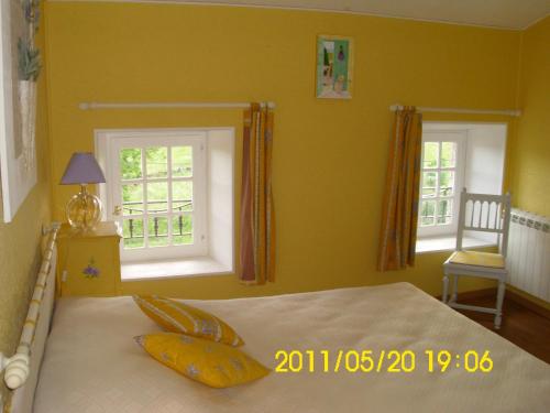 1 dormitorio con 1 cama con paredes y ventanas de color amarillo en Chambre d'hôtes MISTRAL, en Villard