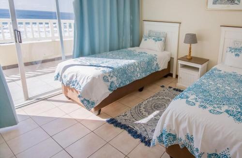巴利托的住宿－Ballito Shores Simbalina " Family-oriented "，一间带两张床的卧室,享有海景