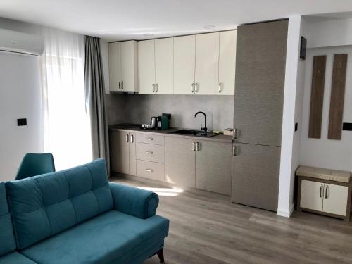 Il comprend un salon avec un canapé bleu et une cuisine. dans l'établissement Modern and New Apartments in North of Timisoara - PNM Residence, à Uisenteş
