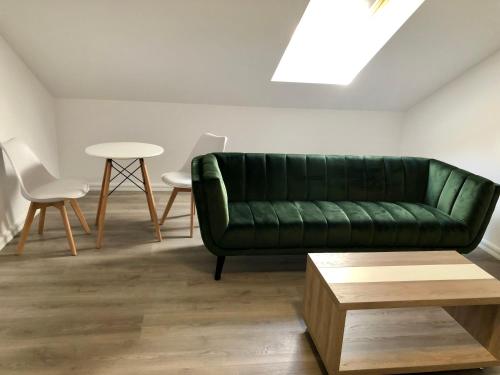 a living room with a green couch and a table at Modern and New Apartments in North of Timisoara - PNM Residence in Dumbrăviţa