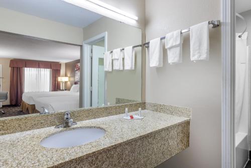 a bathroom with a sink and a large mirror at Days Inn by Wyndham St. Robert Waynesville/Ft. Leonard Wood in Saint Robert