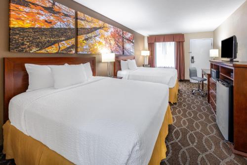 um quarto de hotel com duas camas e uma televisão em Days Inn by Wyndham St. Robert Waynesville/Ft. Leonard Wood em Saint Robert