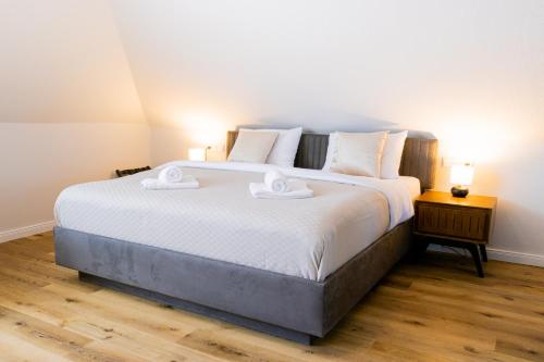 a bedroom with a large bed with two towels on it at Strandnahe Ferienwohnung - sehr modern und hochwertig eingerichtet, inklusive Parkplatz, Gartenzugang und Fahrradunterstellmöglichkeit in Scharbeutz