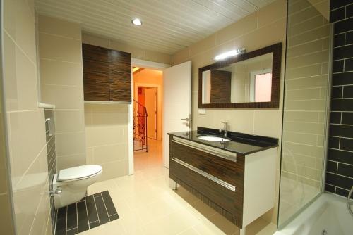 a bathroom with a toilet and a sink and a mirror at Sadev Turizm Belek Family Villas in Belek