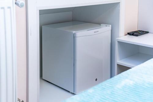 a small white refrigerator in a white room at HB apartments Laghidze in Tbilisi City