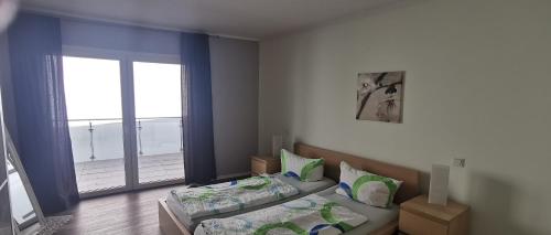 a bedroom with two beds and a large window at Ferienwohnung City in Esens