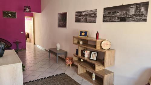 a living room with purple walls and wooden shelves at Casa Rosa in Sogliano Cavour
