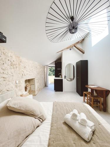 a bedroom with a large bed with towels on it at La Parenthèse, joli studio avec terrasse in Valeuil