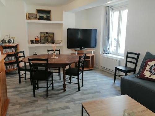- un salon avec une table, des chaises et une télévision dans l'établissement F Logement entier, à Courtenay