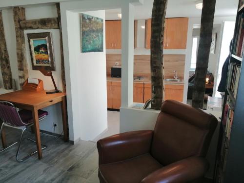 a living room with a couch and a table and a kitchen at F Logement entier in Courtenay