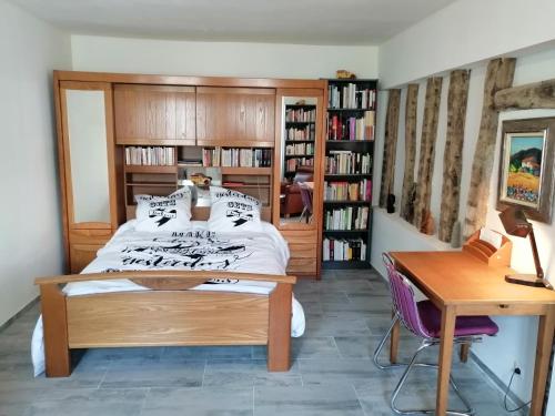 a bedroom with a bed and a desk and book shelves at F Logement entier in Courtenay