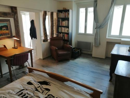 a room with a bed and a chair and a desk at F Logement entier in Courtenay