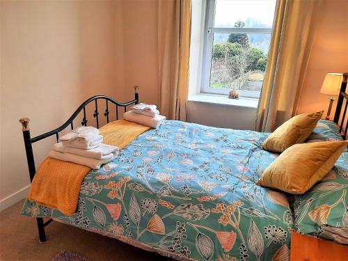 a bedroom with a bed with towels on it at The Granite House in Newton Stewart