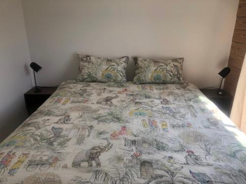 ein Schlafzimmer mit einem großen Bett mit einer Decke in der Unterkunft Gîte entre Golfe du Morbihan et Presqu'île in Surzur