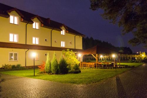 a building with a picnic table in front of it at night at Hotel TiM in Cekanowo