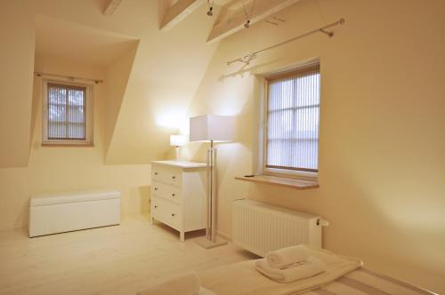 a room with a bed and a dresser and two windows at Space in Szklarska Poręba
