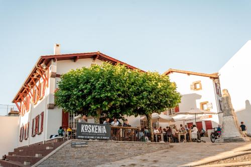 un grupo de personas sentadas fuera de un edificio en AUBERGE KOSKENIA en Bidart