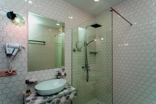 a bathroom with a glass shower and a sink at Betlemi Hotel in Tbilisi City