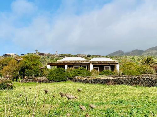 dom pośrodku pola w obiekcie Dammuso Pensare alla Luna w mieście Pantelleria