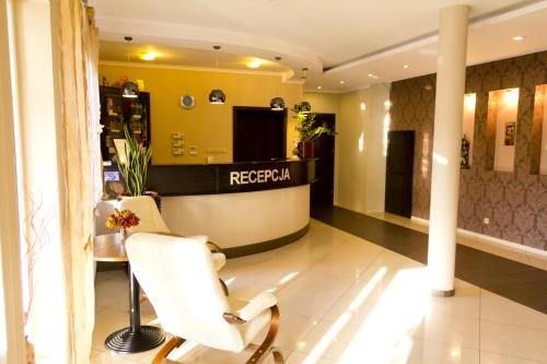a salon with a white chair and a reception desk at Hotel TiM in Cekanowo