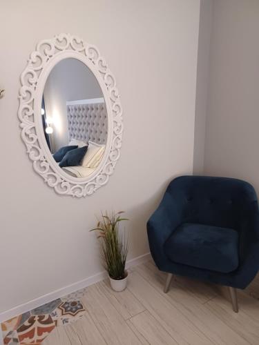 a living room with a blue chair and a mirror at Tara Deluxe Apartment in Varna City