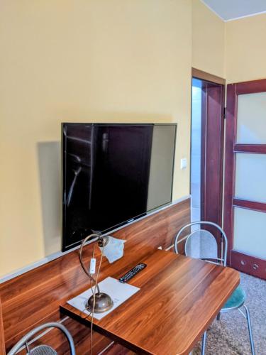a room with a wooden table with a large television at MDS Wielichowo in Wielichowo