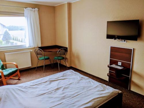 a hotel room with a bed and a desk and a television at MDS Wielichowo in Wielichowo