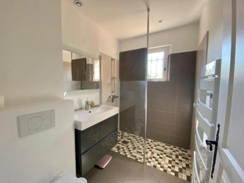 a white bathroom with a sink and a shower at Villa vue mer donnant sur le Golfe de St Tropez, 2 chambres, 6 pers, piscine commune in Saint-Tropez