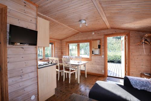 Cabaña de madera con comedor y mesa en Holiday home on southern Gotland en Stånga