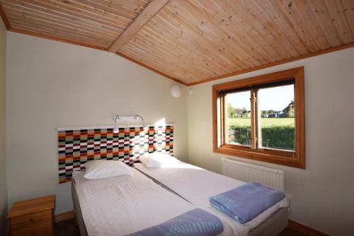 1 dormitorio con cama y ventana en Holiday home on southern Gotland en Stånga