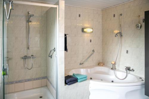 a bathroom with a tub and a shower and a bath tub at Ferienwohnung Gunnar-Ferien in Almdorf in Almdorf