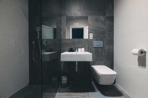 a bathroom with a sink and a toilet and a shower at ATRIO Apartments 2 in Trenčín