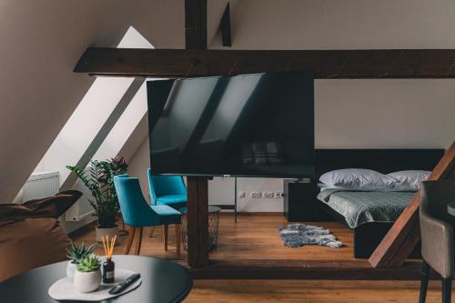 a living room with a large television and a bed at ATRIO Apartments 2 in Trenčín