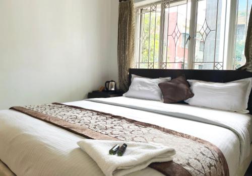 a bedroom with a large bed with a window at The Aster Homestay - Bedrooms & Apartments in Kolkata